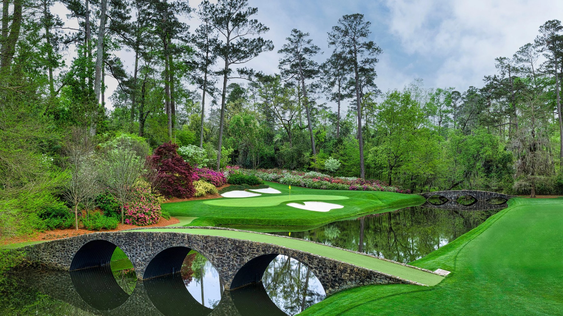 Rae's Creek at Amen Corner — stone bridge, azaleas, and a green that looks like a garden and plays like an examination.